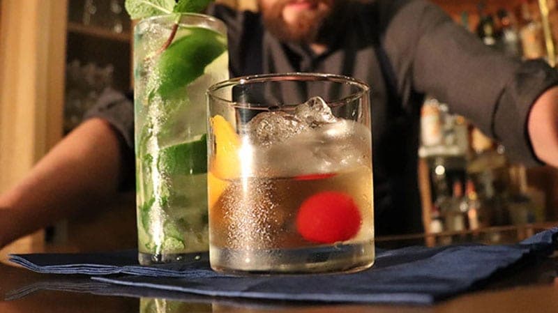 A cocktail served over a block of crystal-clear ice